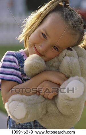Portrait of a girl holding a teddy bear smiling View Large Photo Image Stock Photo - Portrait of a girl holding a teddy bear smiling. Fotosearch