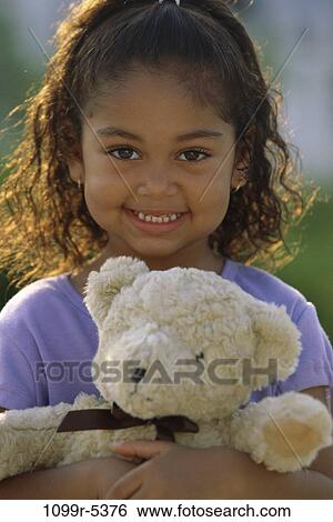 Portrait of a girl holding a teddy bear smiling View Large Photo Image Stock Photograph - Portrait of a girl holding a teddy bear smiling. Fotosearch
