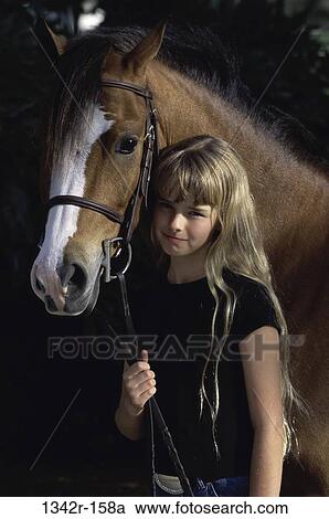 Portrait of a girl holding a Welsh pony View Large Photo Image Stock Image - Portrait of a girl holding a Welsh pony. Fotosearch
