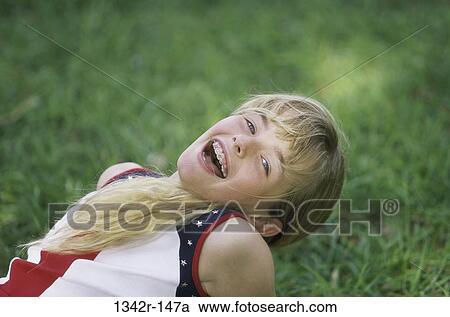Portrait of a girl lying on a lawn smiling View Large Photo Image Stock Image - Portrait of a girl lying on a lawn smiling. Fotosearch