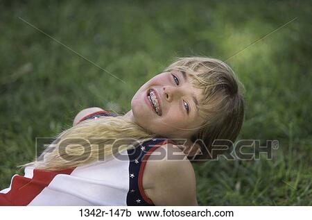 Portrait of a girl lying on a lawn smiling View Large Photo Image Stock Image - Portrait of a girl lying on a lawn smiling. Fotosearch