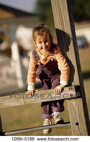 Portrait of a girl playing on a jungle gym View Large Photo Image Stock Photo - Portrait of a girl playing on a jungle gym. Fotosearch