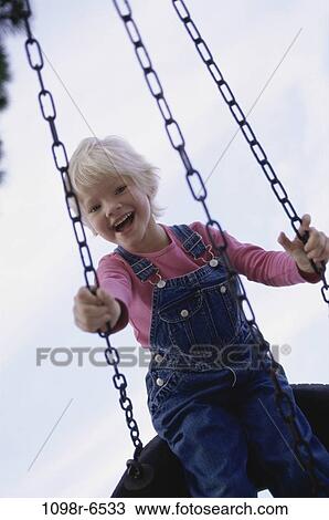 Portrait of a girl sitting on a swing View Large Photo Image Stock Image - Portrait of a girl sitting on a swing. Fotosearch