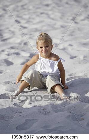 Portrait of a girl sitting on the beach View Large Photo Image Stock Photo - Portrait of a girl sitting on the beach. Fotosearch