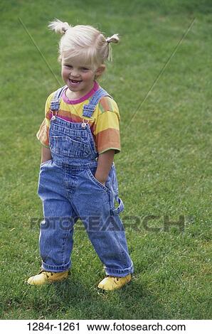 Stock Image - Portrait of a girl standing on a lawn. Fotosearch
