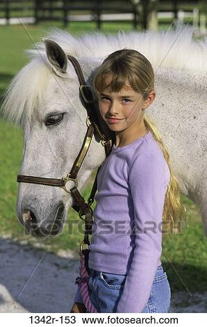 Portrait of a girl standing with a Shetland pony View Large Photo Image Stock Image - Portrait of a girl standing with a Shetland pony. Fotosearch