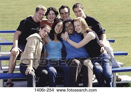 Portrait of a group of teenagers sitting together smiling View Large Photo Image Picture - Portrait of a group of teenagers sitting together smiling. Fotosearch