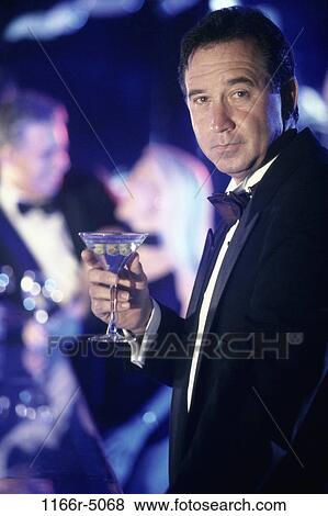 Portrait of a man holding a martini glass View Large Photo Image Stock Photo - Portrait of a man holding a martini glass. Fotosearch