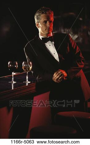 Stock Image - Portrait of a man leaning against a bar. Fotosearch