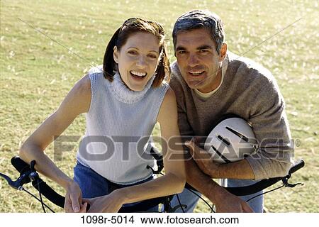 Portrait of a mid adult couple with bicycles View Large Photo Image Picture - Portrait of a mid adult couple with bicycles. Fotosearch