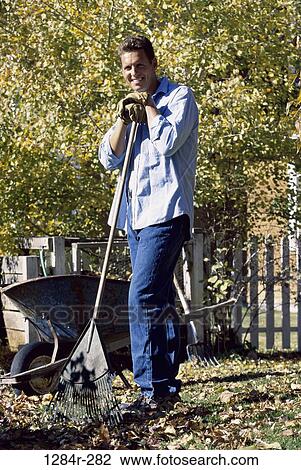 Portrait of a mid adult man standing with a rake View Large Photo Image Stock Image - Portrait of a mid adult man standing with a rake. Fotosearch