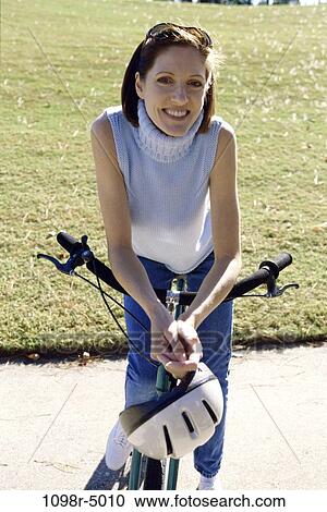 Portrait of a mid adult woman standing with a bicycle View Large Photo Image Stock Image - Portrait of a mid adult woman standing with a bicycle. Fotosearch