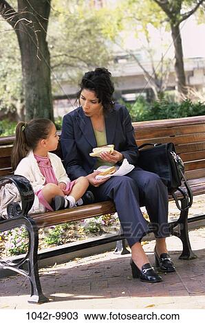 Portrait of a mother and daughter sitting on a park bench View Large Photo Image Stock Image - Portrait of a mother and daughter sitting on a park bench. Fotosearch