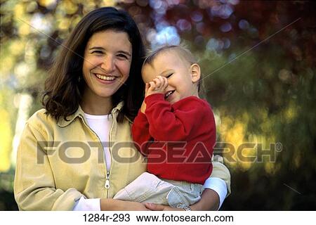 Portrait of a mother holding her baby boy in a park smiling View Large Photo Image Stock Image - Portrait of a mother holding her baby boy in a park smiling. Fotosearch