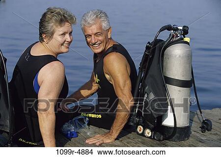 Portrait of a senior couple sitting on a pier with scuba gear View Large Photo Image Picture - Portrait of a senior couple sitting on a pier with scuba gear. Fotosearch