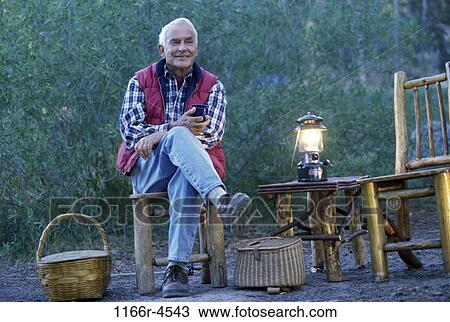 Stock Image - Portrait of a senior man camping. Fotosearch