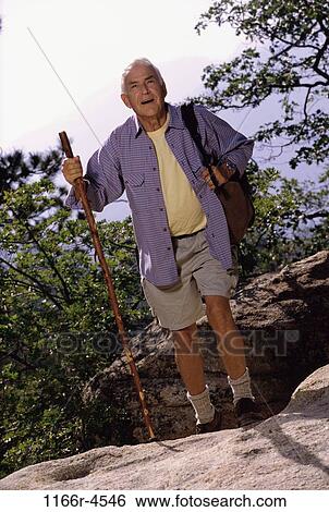 Stock Photograph - Portrait of a senior man holding a hiking pole. Fotosearch