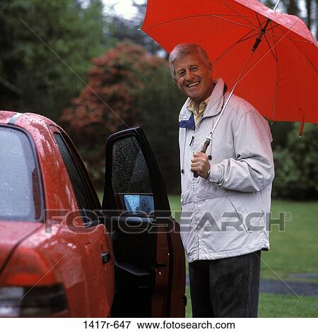 Stock Photo - Portrait of a senior man opening a car door. Fotosearch