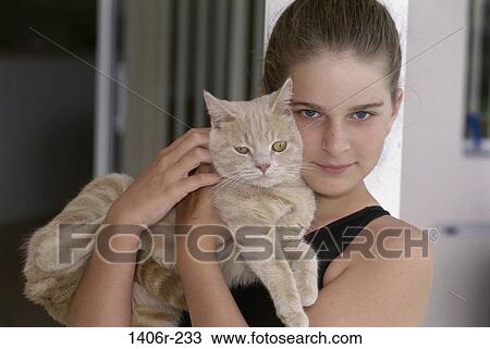 Stock Image - Portrait of a teenage girl holding a cat. Fotosearch
