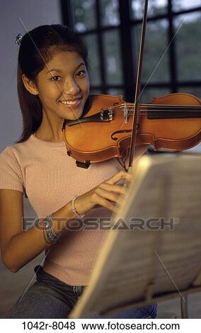 Portrait of a teenage girl playing the violin View Large Photo Image Stock Photo - Portrait of a teenage girl playing the violin. Fotosearch