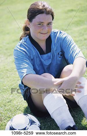 Portrait of a teenage girl sitting on a lawn with a soccer ball View Large Photo Image Stock Photo - Portrait of a teenage girl sitting on a lawn with a soccer ball. Fotosearch