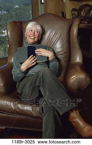 Portrait of a woman holding a book View Large Photo Image Stock Photography - Portrait of a woman holding a book. Fotosearch