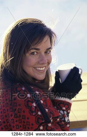Portrait of a woman holding a hot drink in a cup View Large Photo Image Picture - Portrait of a woman holding a hot drink in a cup. Fotosearch