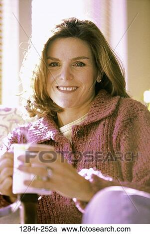 Stock Image - Portrait of a woman holding a mug. Fotosearch
