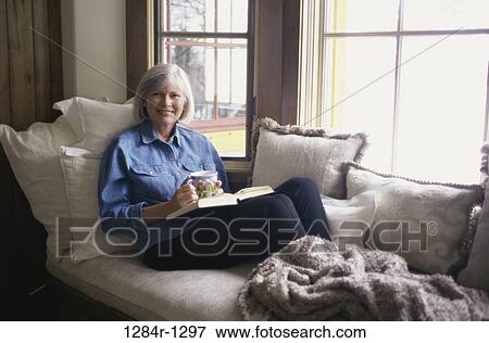 Portrait of a woman sitting on a couch View Large Photo Image Stock Photo - Portrait of a woman sitting on a couch. Fotosearch
