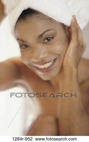 Stock Image - Portrait of a woman with a towel wrapped around her head. Fotosearch
