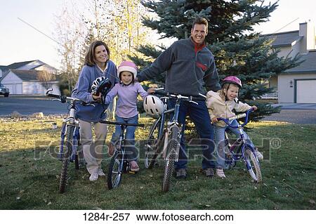 Portrait of a young couple and their two children on bicycles View Large Photo Image Stock Photo - Portrait of a young couple and their two children on bicycles. Fotosearch