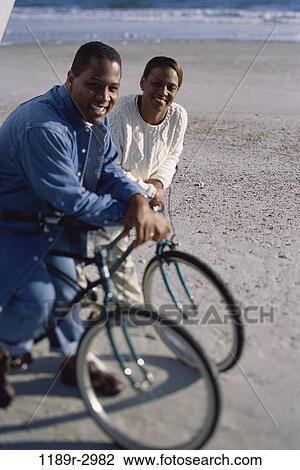 Portrait of a young couple on bicycles at the beach View Large Photo Image Stock Image - Portrait of a young couple on bicycles at the beach. Fotosearch