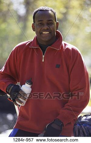 Stock Photo - Portrait of a young man holding a bottle. Fotosearch