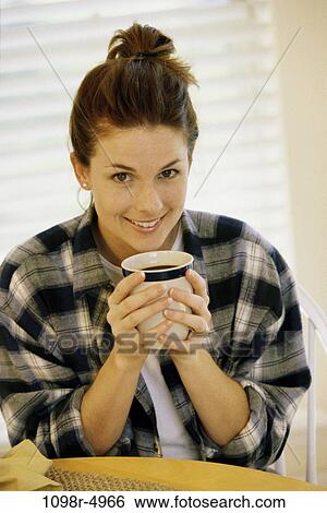 Stock Photograph - Portrait of a young woman holding a mug. Fotosearch