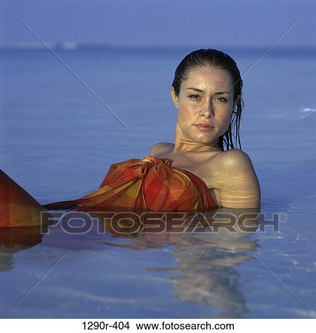 Picture - Portrait of a young woman lying on the beach. Fotosearch