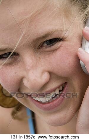 Stock Image - Portrait of a young woman talking on a mobile phone. Fotosearch
