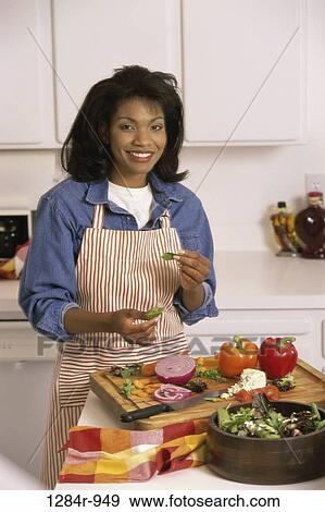 Portrait of a young woman wearing an apron and chopping vegetables View Large Photo Image Stock Photo - Portrait of a young woman wearing an apron and chopping vegetables. Fotosearch