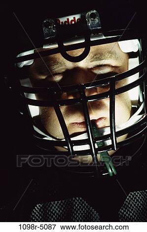 Stock Photo - Portrait of an American football player wearing a helmet. Fotosearch