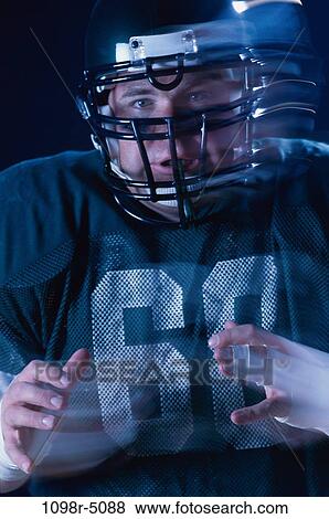 Stock Photo - Portrait of an American football player wearing a helmet. Fotosearch