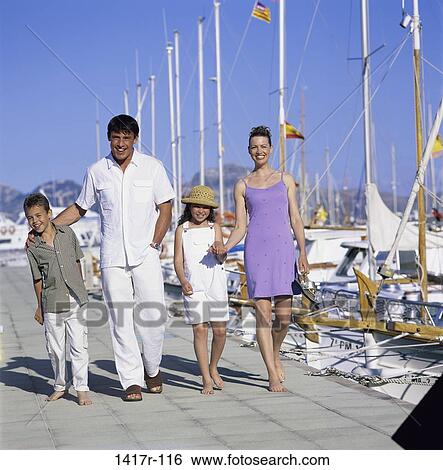 Stock Photograph - Portrait of parents and their children walking on a pier. Fotosearch