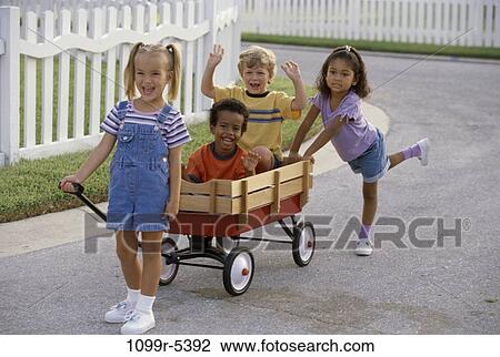 Portrait of two boys and two girls playing with a push cart View Large Photo Image Stock Image - Portrait of two boys and two girls playing with a push cart. Fotosearch