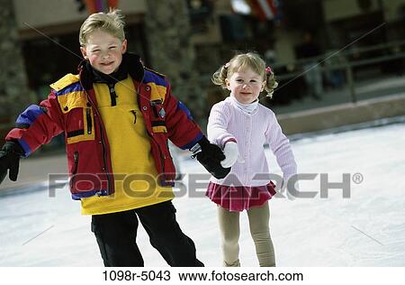 Stock Image - Portrait of two children ice skating together. Fotosearch