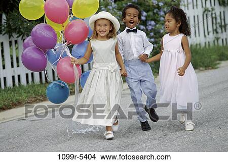 Portrait of two girls and a boy walking together holding hands View Large Photo Image Picture - Portrait of two girls and a boy walking together holding hands. Fotosearch