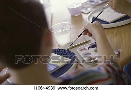 Rear view of a boy painting with a paint brush View Large Photo Image Stock Photo - Rear view of a boy painting with a paint brush. Fotosearch