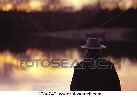 Rear view of a mature man standing near a lake View Large Photo Image Stock Photo - Rear view of a mature man standing near a lake. Fotosearch