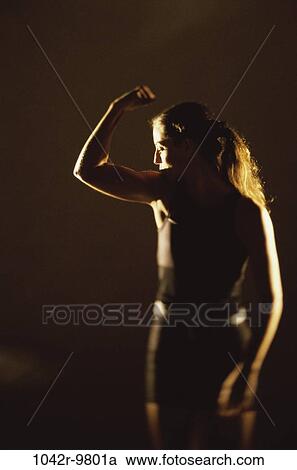 Stock Image - Rear view of a woman flexing her biceps. Fotosearch