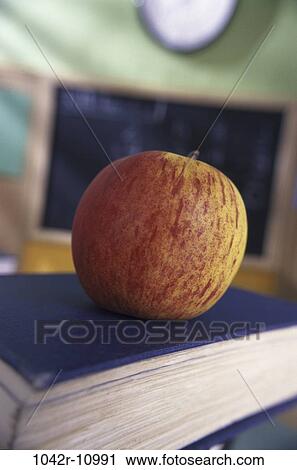 Red apple on a book View Large Photo Image Stock Image - Red apple on a book. Fotosearch