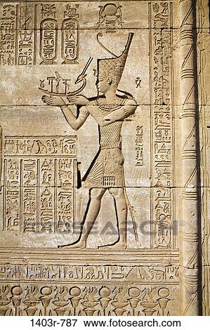 Relief carving of a man holding a boat on the outer wall of the Roman Mammisi at the Dendera Temple Complex in Egypt View Large Photo Image Stock Photo - Relief carving of a man holding a boat on the outer wall of the Roman Mammisi at the Dendera Temple Complex in Egypt. Fotosearch