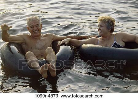 Senior couple floating on inner tubes View Large Photo Image Stock Photo - Senior couple floating on inner tubes. Fotosearch