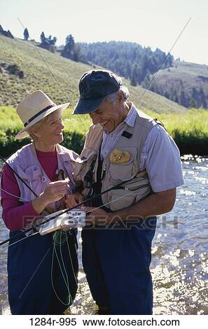 Stock Photography - Senior couple holding fishing rods. Fotosearch